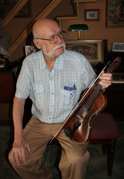 Herb Mandel with the refurbished violin his father brought with him when he emigrated from Germany in the early 1920s.